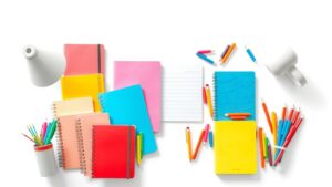 Een opgeruimd bureau met kleurrijke planners en notitieboeken.